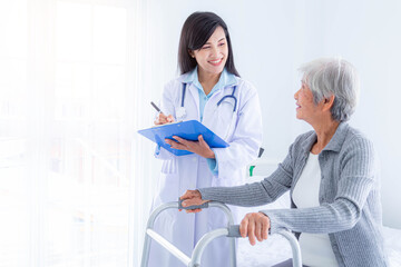 Smiling senior woman and doctor with clipboard meeting in medical office.
