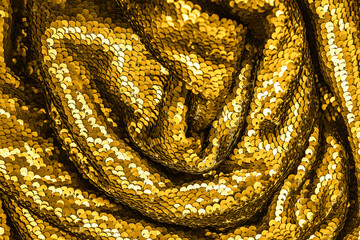 Golden shiny fabric with sequins, abstract background.
