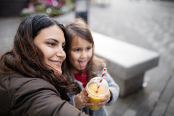 Mother and daughter taking a selfie while making funny faces