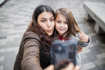 Mother and daughter taking a selfie while making funny faces
