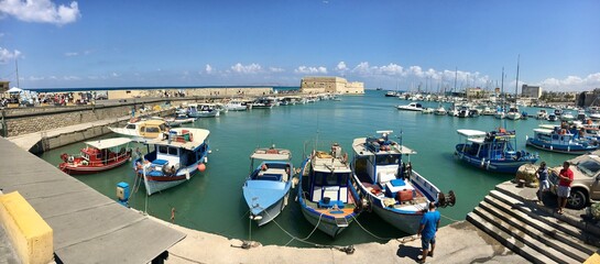 Heraklion, Crete - September, 2015: Fishing boats and Venetian Fortress in Heraklion harbor. Crete, Greece