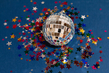 silver disco ball with colored sparkles on blue background, greeting card wallpaper template with...