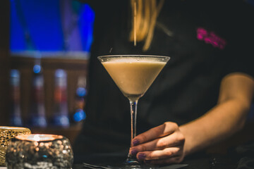 A Campfire Martini cocktail being strained into a chilled martini glass.