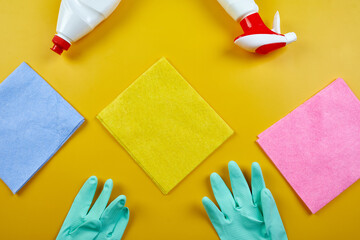 Flat lay of variety house cleaning product on yellow table with copy space