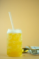 Glass of light beer with ice and straw