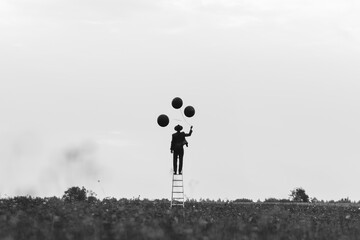 surreal photo of a single man in a suit on a staircase with balloons in a field