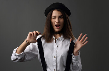 Beautiful girl in a black hat and white shirt with suspenders