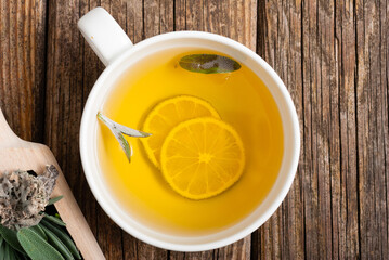 cup of herbal tea and sage, lavender, thyme, iceland lichen herb leaves on scoop