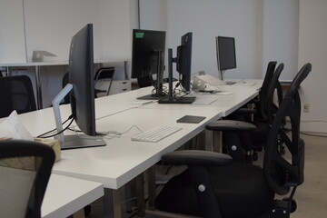A shared workstation in a small business office sits empty after Covid 19 forces everyone to work from home.
