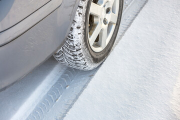 Close-up of car wheels rubber tire in deep snow. Transportation and safety concept.