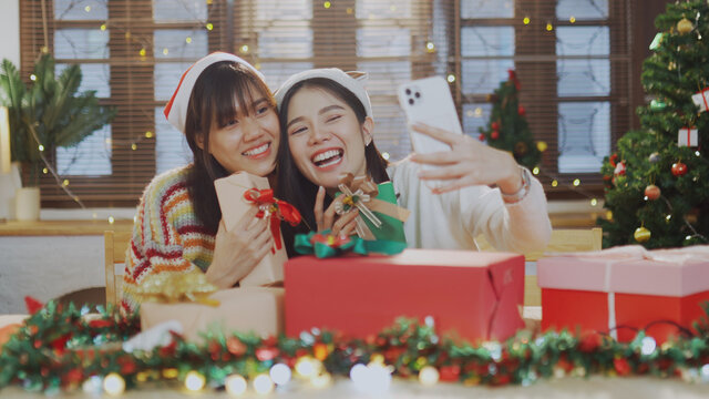 Asian couple woman take a selfie photo together while holding a Christmas gift box
