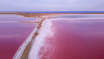 Pink Salt Lake. The picturesque shore of the lagoon is covered with a thick layer of salt formed during the evaporation of water. - obrazy, fototapety, plakaty
