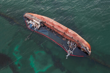 A sunken ship, a sunken tanker near the beach, a wrecked ship on the water. Top view