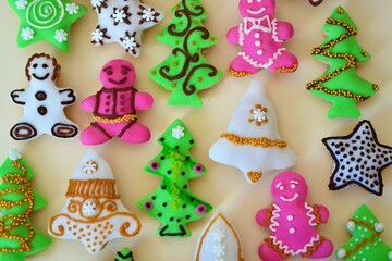 Christmas composition: cookies in the shape of a Christmas tree, gingerbread man, bells and colorful stars decorated on a yellow background