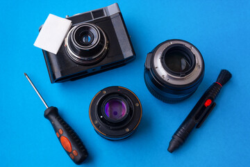 Camera lens repair and cleaning lens on blue background with space for text. Copy space. Top view