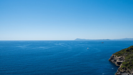 Fototapeta na wymiar Boat sailing on the blue sea and infinite horizon, 