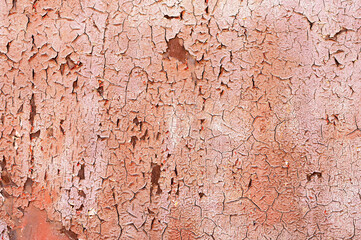 Textured background old faded red paint with white streaks and cracked peeling to rusty metal