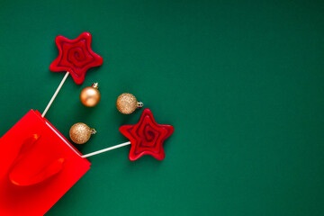Festive christmas decoration with red candy stars and golden bowls over the green background. Christmas and new year concept flatly with space for text.