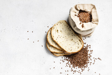 Flax seeds in a sack, sliced bread. Space for text, top view, flat lay.