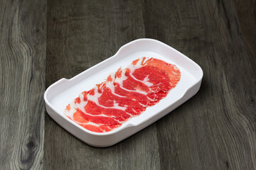fresh raw pork, meat ,beef, belly, sliced on square plate  on wood, wooden background,set shabu, hot pot ingredients.