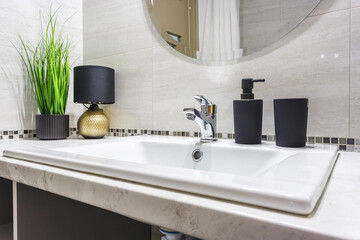 Ceramic Water tap sink with faucet with black soap and shampoo dispensers in expensive bathroom