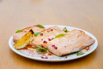 Grilled fish garnished with lemon and basil top view.  Decorated catering banquet menu with different food snacks and appetizers with sandwich.
