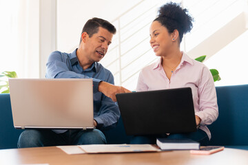 Fototapeta premium Happy mature business man collaborating and discussing project plans on sofa of business lounge. Teamwork, corporate, planning, strategy concept..