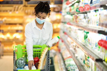 African American Woman Buying Food Standing With Pushcart In Store