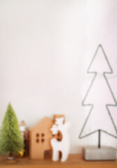 Blurred vertical photo, text cover. Christmas tree with a house, a deer and a Christmas tree.