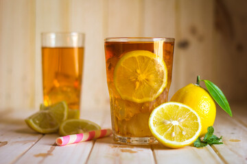 Glasses of ice tea with lemon slices  on wooden background