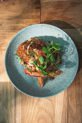 Freshly baked chicken kiev on a bed of new potatoes, garnished with micro herbs.
