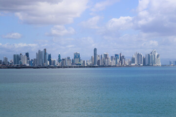 Obraz premium Skyline in distance with gulf front on cloudy day; cityscape background with copy space