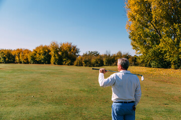 Portrait of senior golfer looking the golf course in autumn