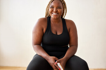 plump, plus size african american woman in black sportswear posing in studio, concept of sport,...