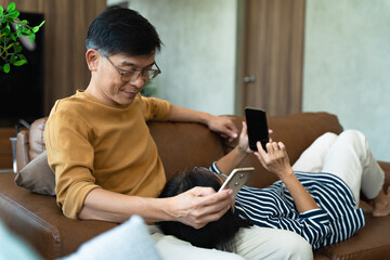 Senior couple relaxing together at home using mobile phone, online technology, senior with phone, 