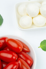 Mozzarella cheese, cherry tomatoes and basil leaves in composition