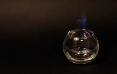 Close-up of a glass with a burning liquid in blue