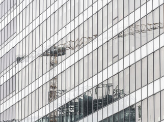 Fototapeta na wymiar Big crane reflection in the windows of an office building