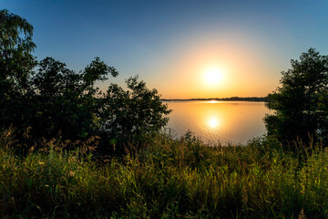 Fototapeta na wymiar Golden sunset on the lake in Russia. Landscape summer.