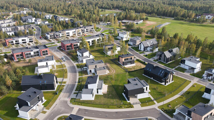 Aerial view of new cottage village of two-storey houses. Low-rise development. Apartments by countryside. View of newly built cottages.