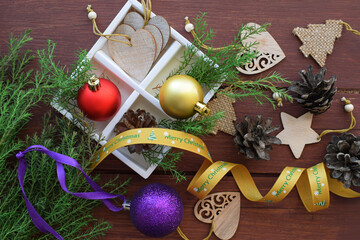 Coniferous branches and Christmas balls on a wooden background.