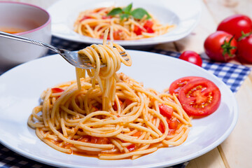 Spaghetti pasta with and tomato sauce on wood background