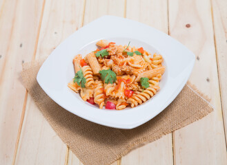 Spaghetti pasta with and tomato sauce on wood background