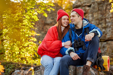 caucasian couple camping, active romantic couple in love traveling and hiking. tourists are exploring together. sunny autumn day