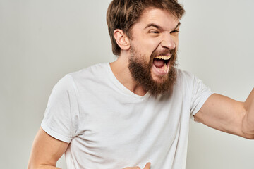 Fototapeta premium man in white t-shirt emotions expressions gesture with hands cropped view light background