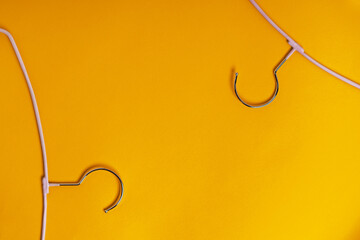 Clothes hangers are on a yellow background, top view. The concept of fashion