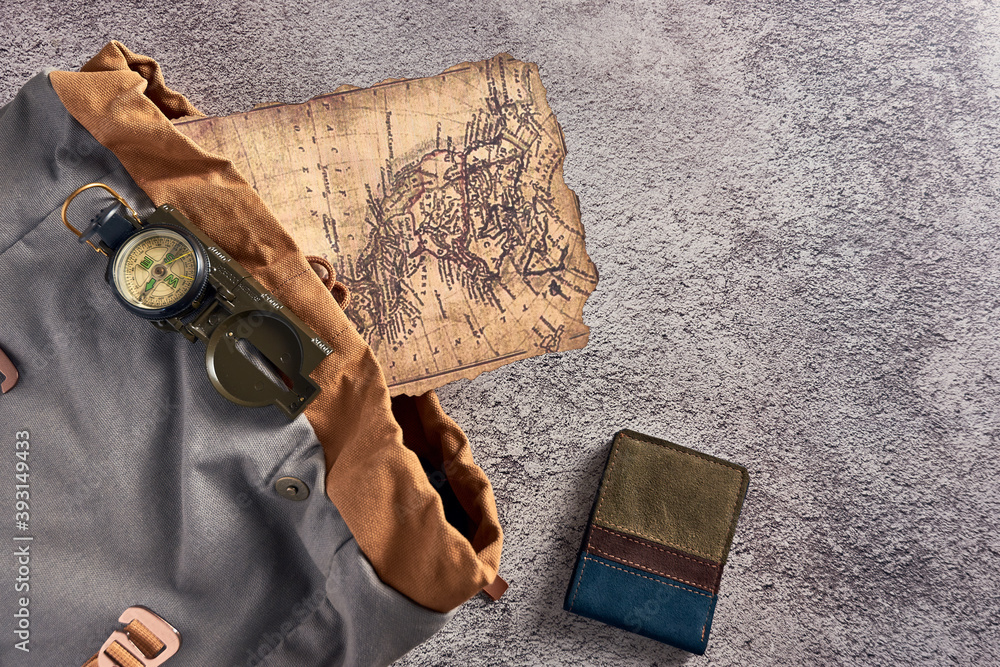 Aufkleber top view closeup of a compass placed on a colorful fabric next to an ancient map and a wallet