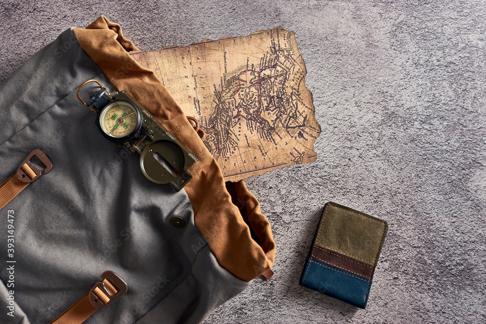 Aufkleber top view closeup of a compass placed on a colorful fabric next to an ancient map and a wallet