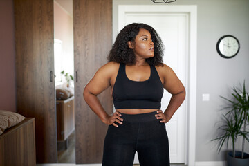 young plus size black woman doing sport fitness exercises at home alone, in sportswear. morning begins with gymnastics