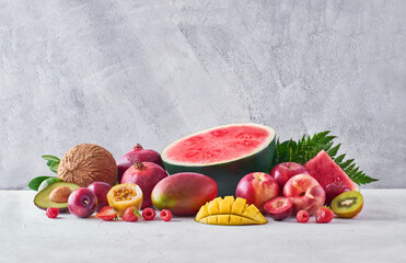 Set of assorted sweet exotic fruits and berries arranged on table in studio